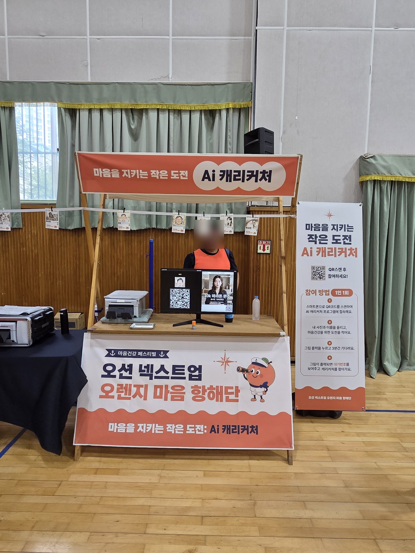 오션 넥스트업 오렌지 마음 항해단 부스 설치 전경, 배너와 출력된 캐리커처 샘플들